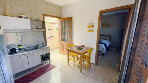 eine Küche mit einem Tisch und einem kleinen Tisch mit einem Tisch in der Unterkunft Bella Praia apartamento Girassol in Passo de Torres