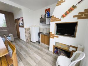 帕蘇迪托雷斯的住宿－Bella Praia apartamento Girassol，带电视的客厅和带壁炉的厨房。