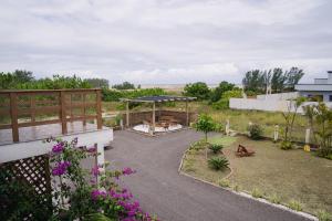 Blick auf einen Garten mit einem Pavillon in der Unterkunft Bella Praia apartamento Girassol in Passo de Torres