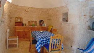 a dining room with a blue and white table and chairs at Trullo Oasi di Pace in Ceglie Messapica