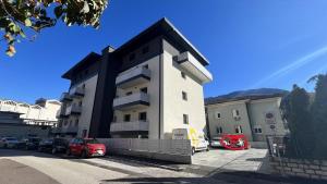 a building with cars parked in a parking lot at Bolghera House in Trento
