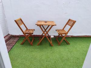 2 sillas de madera y una mesa en el césped en apartamento con jacuzzi, El Rincón de Ayud, en Calatayud