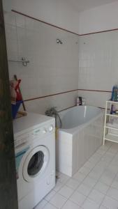 een badkamer met een wasmachine en een bad bij Trullo Oasi di Pace in Ceglie Messapica