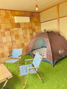 2 Stühle und ein Zelt in einem Zimmer in der Unterkunft ASTERISK＋ in Iwami