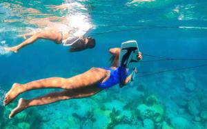 two people in the water playing with a rope at Vahaui Paradis in Avatoru