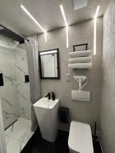 a white bathroom with a sink and a toilet at Apartament Miami in Ełk