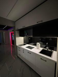 a kitchen with white cabinets and a sink at Apartament Miami in Ełk