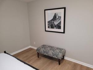 a bedroom with a bench and a picture on the wall at Davenport Dwellings-Three Bedroom in Omaha