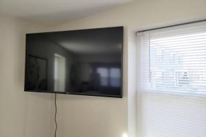 a flat screen tv on a wall next to a window at Davenport Dwellings-Three Bedroom in Omaha