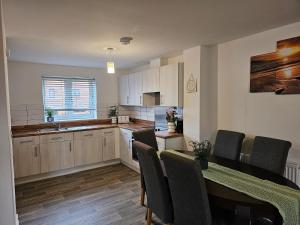 a kitchen with a table and chairs and a dining room at Modern 3 Bedroom Town House in Ipswich in Ipswich