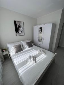 a white bedroom with a large bed with white sheets at A-more accommodation in Split