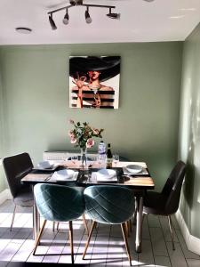 een eetkamer met een houten tafel en stoelen bij Weston Court in Avonmouth