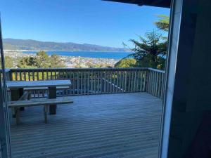 a deck with a bench and a view of the water at 3 bed apartment with stunning harbour views in Lower Hutt