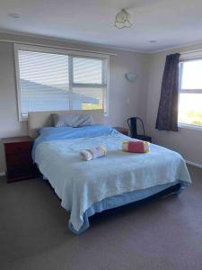 a bedroom with a bed with two towels on it at 3 bed apartment with stunning harbour views in Lower Hutt