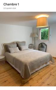 ein Schlafzimmer mit einem großen Bett mit einer Lampe in der Unterkunft Maison Lily en Provence - Gonfaron - 4ch in Gonfaron