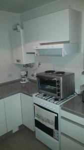 a kitchen with a stove and a microwave at Apartment Nueva Córdoba in Cordoba