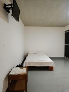 ein Schlafzimmer mit einem Bett und einem TV an der Wand in der Unterkunft Casa Turística Macarena Tierra salvaje in La Macarena