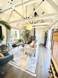 a living room with a swing hanging from the ceiling at Stunning cottage in Christchurch
