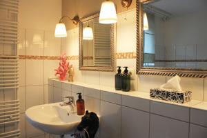 a bathroom with a sink and a mirror at R B Apartment Hamburg Family - 108 qm mit Dachterrasse - Badewanne & Dusche - kostenloses Parken - 2 Schlafzimmer in Hamburg +22 photos