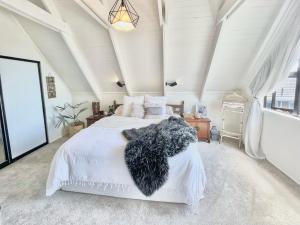 um quarto com uma cama branca e um cobertor preto em Stunning cottage em Christchurch