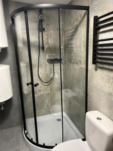una ducha con puerta de cristal en un baño en Apartament przy plaży Marlina, en Niewiesze