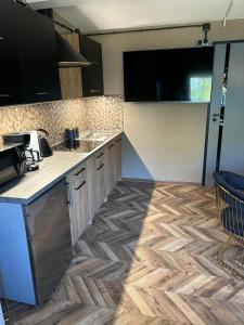 a kitchen with a counter top and wooden floor at Apartament przy plaży Marlina in Niewiesze +7 photos
