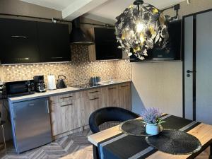 a kitchen with a table and a chandelier at Apartament przy plaży Marlina in Niewiesze
