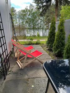 una silla roja sentada en un patio junto a una mesa en Marlina, en Niewiesze
