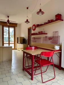 une cuisine avec une table et une chaise rouge dans l'établissement Igea vacanza, à Bellaria-Igea Marina