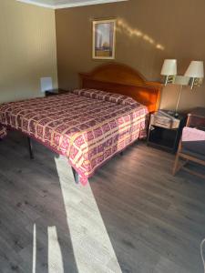Habitación de hotel con cama y silla en Economy Inn - Cullman, en Cullman