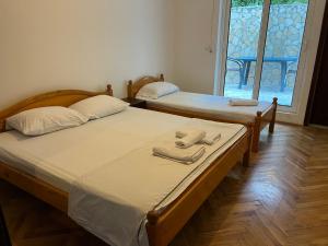 twee bedden in een kamer met handdoeken erop bij Regatta Inn in Ulcinj