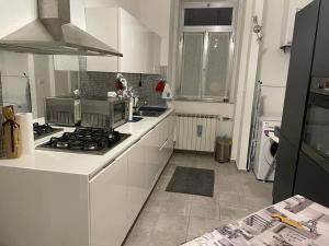 a kitchen with white cabinets and a stove top oven at Casa Vacanze Chiara in Trieste