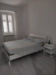 a white bedroom with a bed and a window at Casa Vacanze Chiara in Trieste