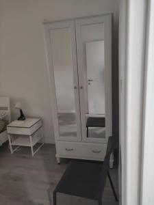 a white cabinet with a chair and a table at Casa Vacanze Chiara in Trieste