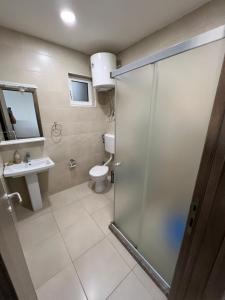 La salle de bains est pourvue d'une douche, de toilettes et d'un lavabo. dans l'établissement Regatta Inn, à Ulcinj
