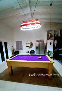 a ping pong table in the middle of a room at The White House in Calliaqua