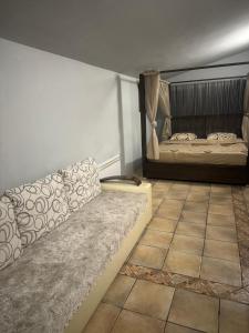 ein Wohnzimmer mit einem Sofa und einem Bett in der Unterkunft Hostel Lejla in Podgorica