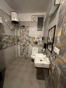 a bathroom with a sink and a toilet in it at Kut House in Pālampur +75 photos