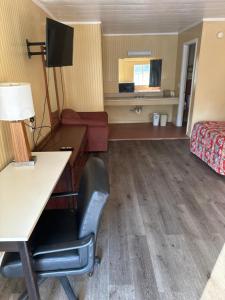 a hotel room with a desk and a chair at Economy Inn - Cullman in Cullman