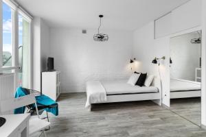ein weißes Schlafzimmer mit einem Bett und einer Badewanne in der Unterkunft Piękne studio z balkonem w centrum Warszawy in Warschau
