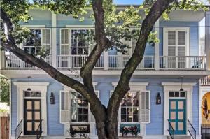 a blue house with a tree in front of it at 1234 New Orleans in New Orleans