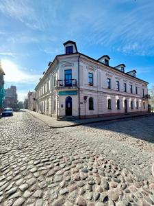 a large white building on a cobblestone street at OLD TOWN Republika - 2 rooms - Self Check In - 24 hours - Free parking in Liepāja