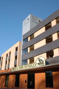 a building with a sign on the side of it at Hotel Dom Henrique in Timóteo