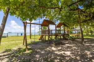 a playground in a park with trees and the ocean at MARE NOSTRUM -VISTA MAR CARNEIROS- 2suítes -ECO RESORT in Praia dos Carneiros