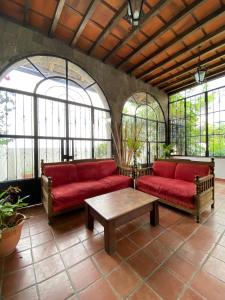 a living room with two red couches and a table at Mikaso Hotel in San Pedro La Laguna