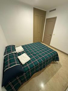 1 dormitorio con 1 cama con 2 toallas en Hotelly Atocha, en Madrid