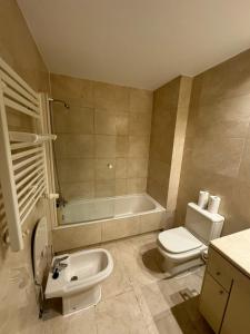 uma casa de banho com um WC, uma banheira e um lavatório. em Hotelly Atocha em Madri
