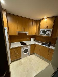 a kitchen with a washing machine and a microwave at Hotelly Atocha in Madrid