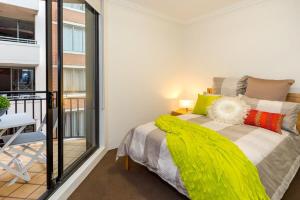 een slaapkamer met een bed en een balkon bij Thriving city location dining hub near CBD in Sydney
