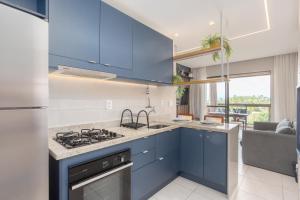 a kitchen with blue cabinets and a stove at MARENOSTRUM -VISTA MAR - PRAIA DOS CARNEIROS - ECO RESORT- 2 Suítes in Praia dos Carneiros
